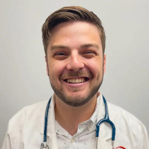 Dr. Payne wearing a white lab coat and smiling at the camera