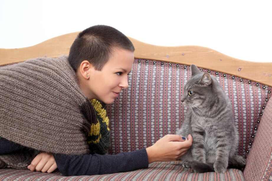 woman petting her cat on the couch