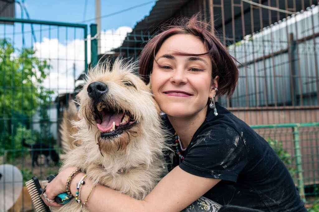 woman outside with her dog and hugging them
