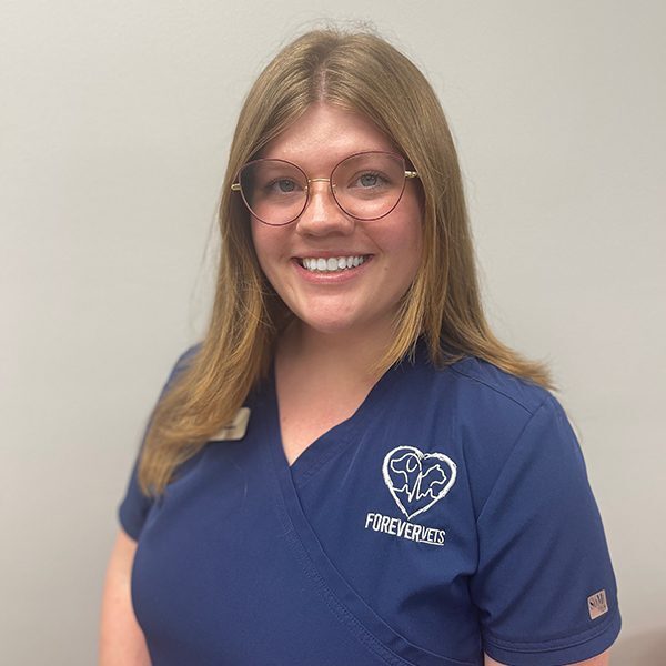 Anslee Patrick wearing blue scrubs and smiling at the camera