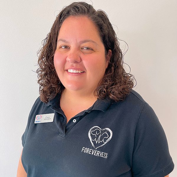 Carrie Songer wearing a blue polo shirt and smiling at the camera