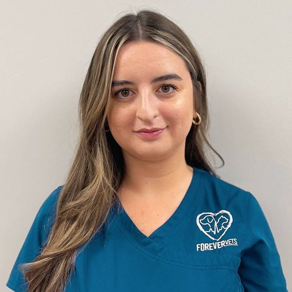 Chloe Owens wearing blue scrubs and smiling at the camera