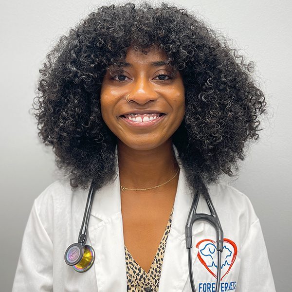 Dr. Aerielle Moss wearing a white lab coat and smiling at the camera