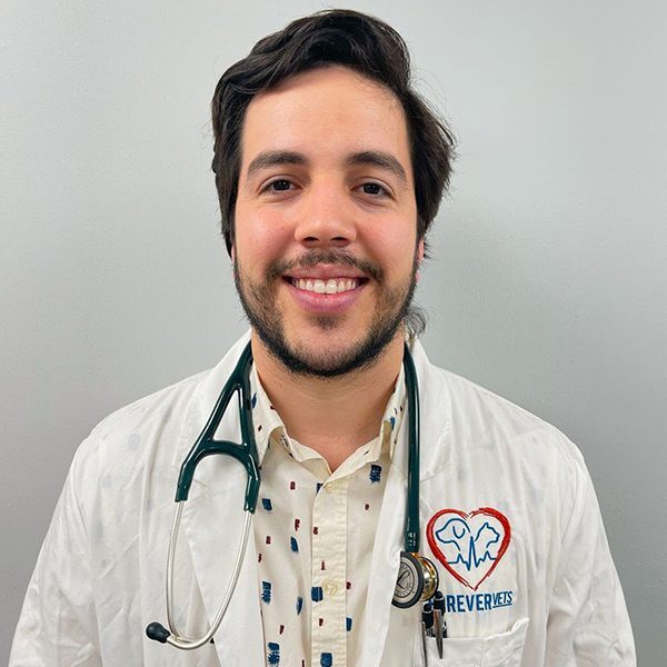 Dr. Alejandro G. Zamot Guzman wearing a white lab coat and smiling at the camera