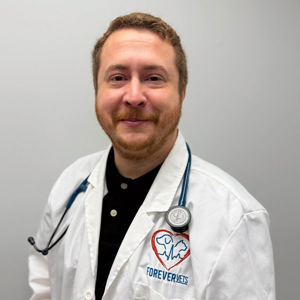 Dr. Amir Razavipour wearing a white lab coat and smiling at the camera