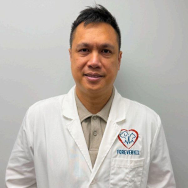 Dr. Christian Legaspi wearing a white lab coat and smiling at the camera