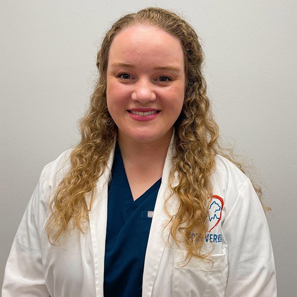 Dr. Hanna Macgregor wearing a white lab coat and smiling at the camera