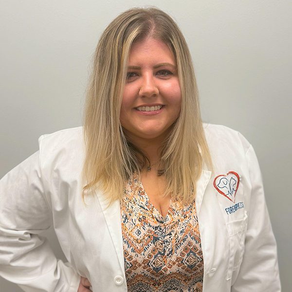 Dr. Kylie Tank wearing a white lab coat and smiling at the camera