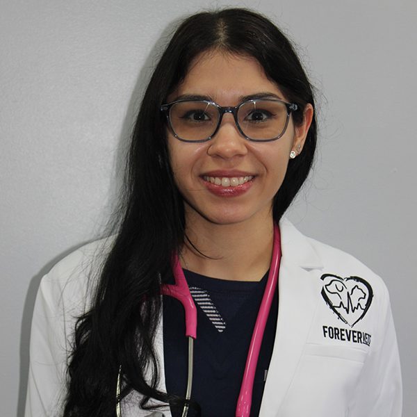 Dr. Marie Rosario wearing a white lab coat and smiling at the camera