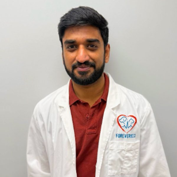 Dr. Pavan Uppala wearing a white lab coat and smiling at the camera