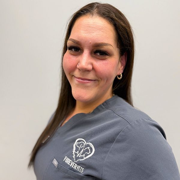 Helen Robinson wearing grey scrubs and smiling at the camera