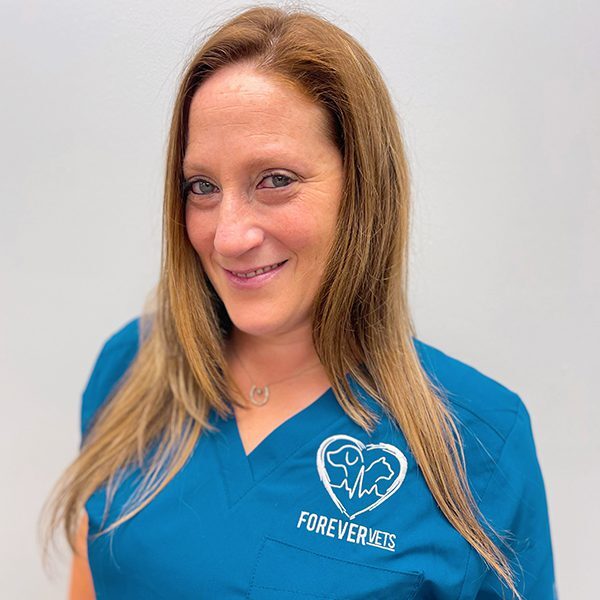 Lara Heil wearing blue scrubs and smiling at the camera