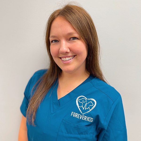 Nicole Humphrey wearing blue scrubs and smiling at the camera