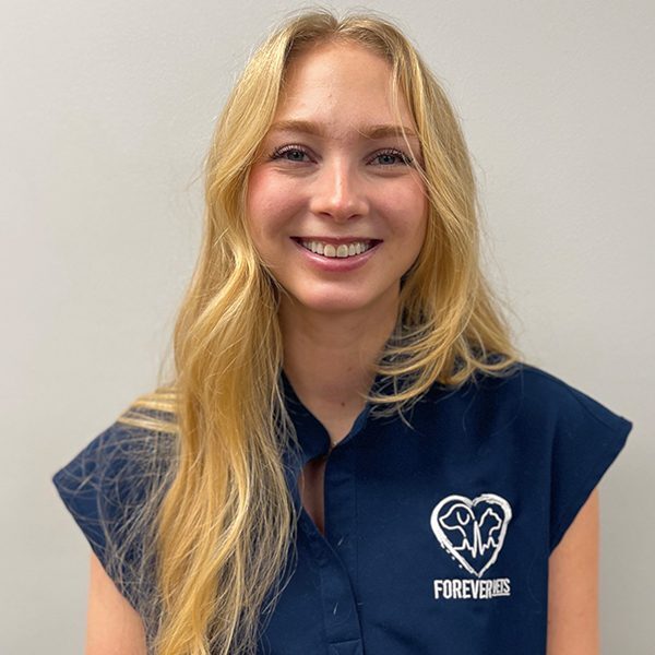 Olivia Mcgehee wearing blue scrubs and smiling at the camera