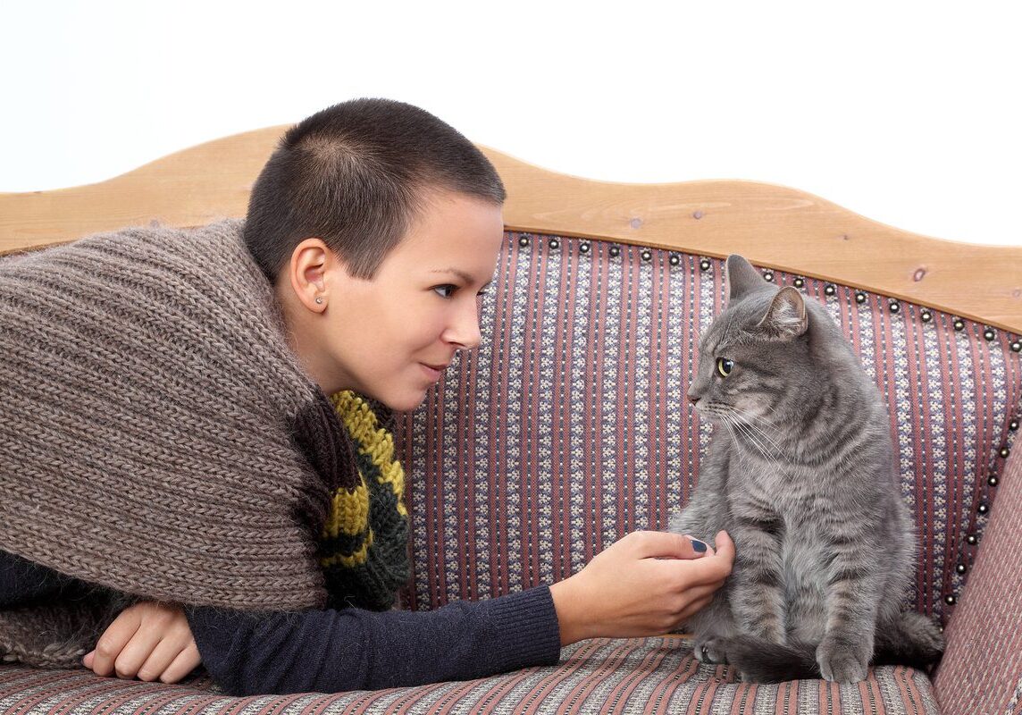 woman petting her cat on the couch
