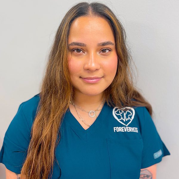 Veronica Medina wearing blue scrubs and smiling at the camera