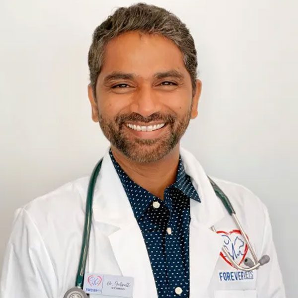 Dr G wearing a white lab coat and smiling at the camera