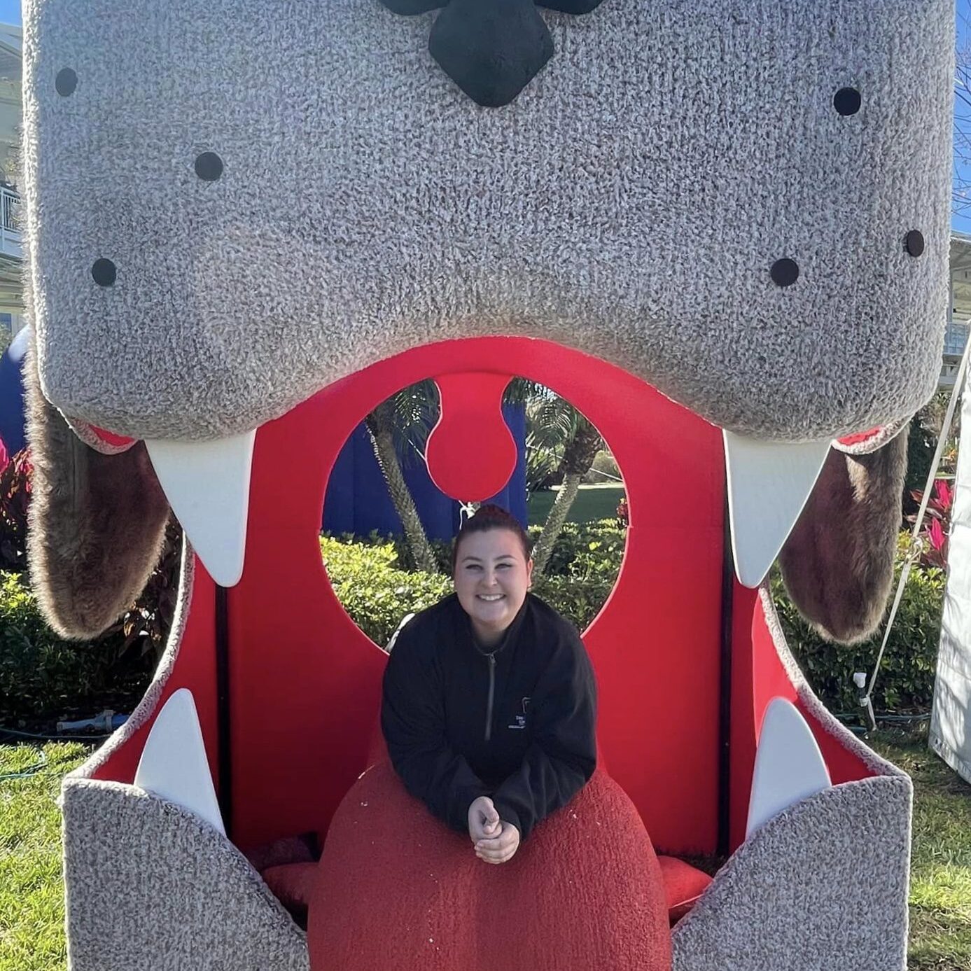 Dr Heiar smiling next to a dog cut out at a fair