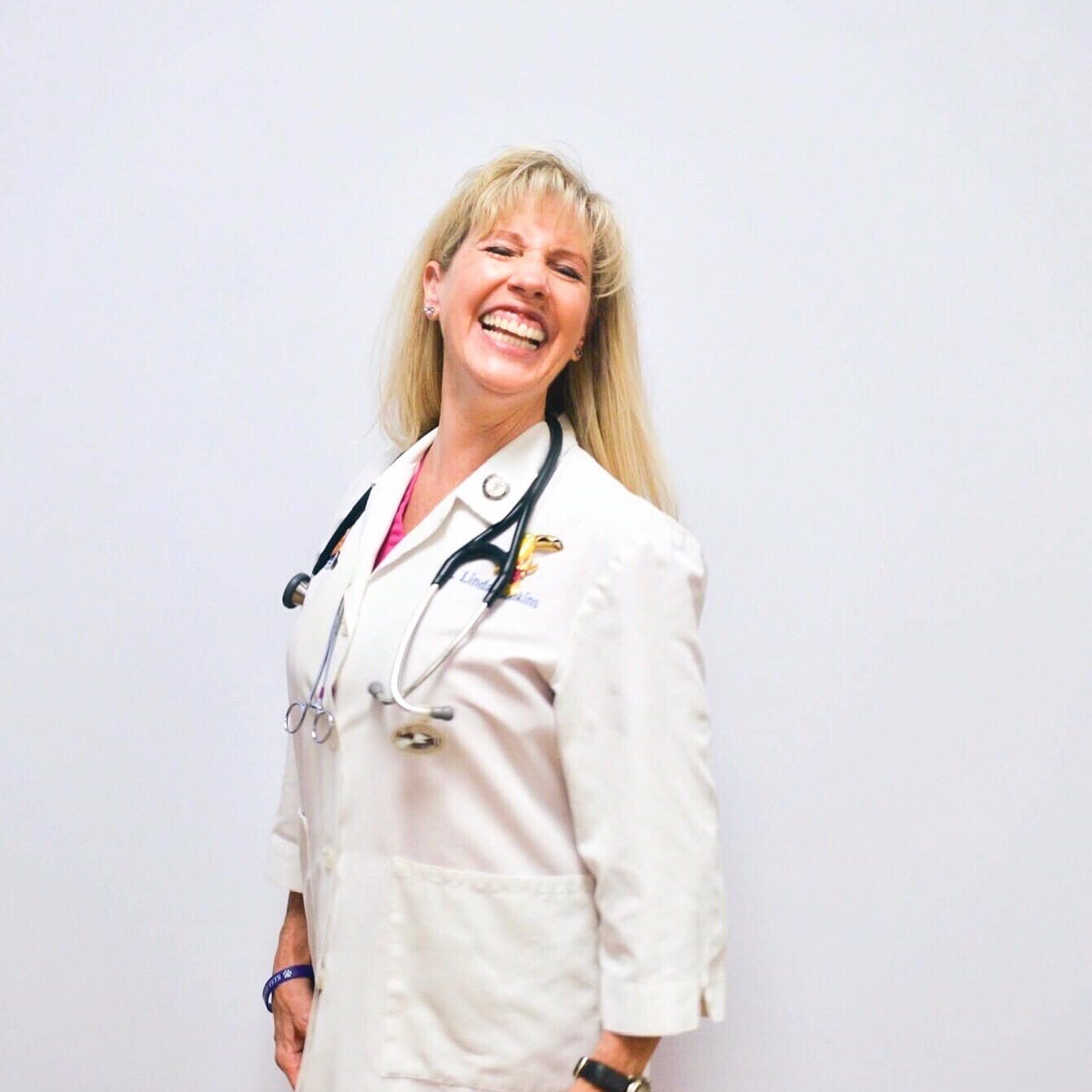 Dr Junk wearing a white lab coat and smiling at the camera