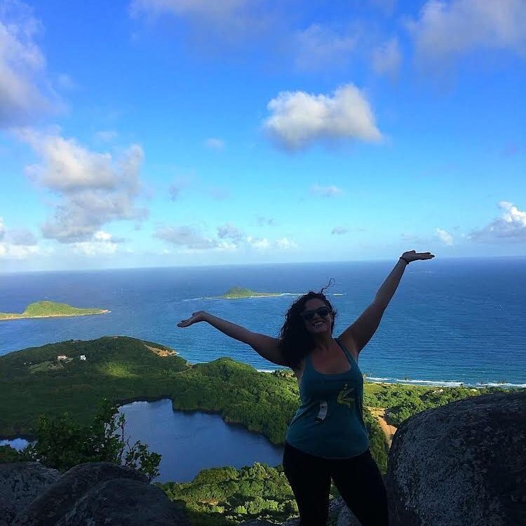 Dr Quinn hiking with the sea behind her