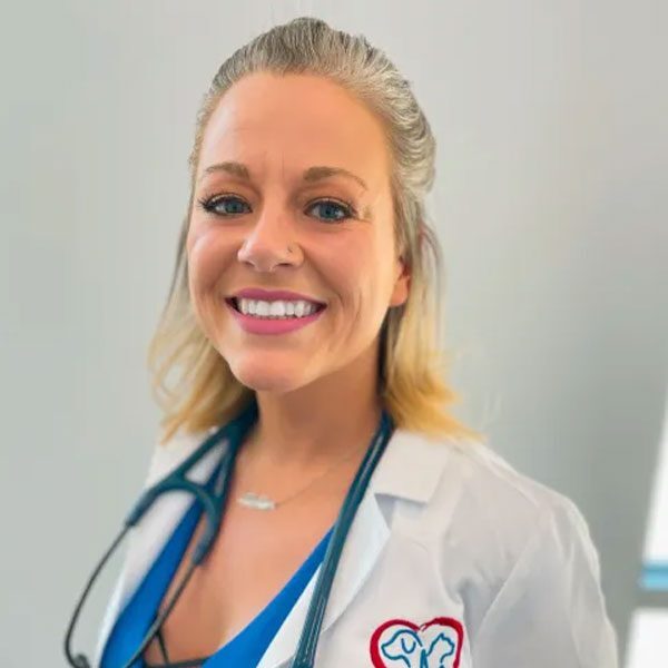 Dr Shannon Quinn wearing a white lab coat and smiling at the camera