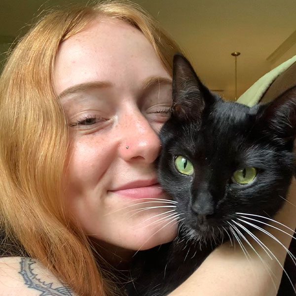Emma Bittner smiling while holding black cat