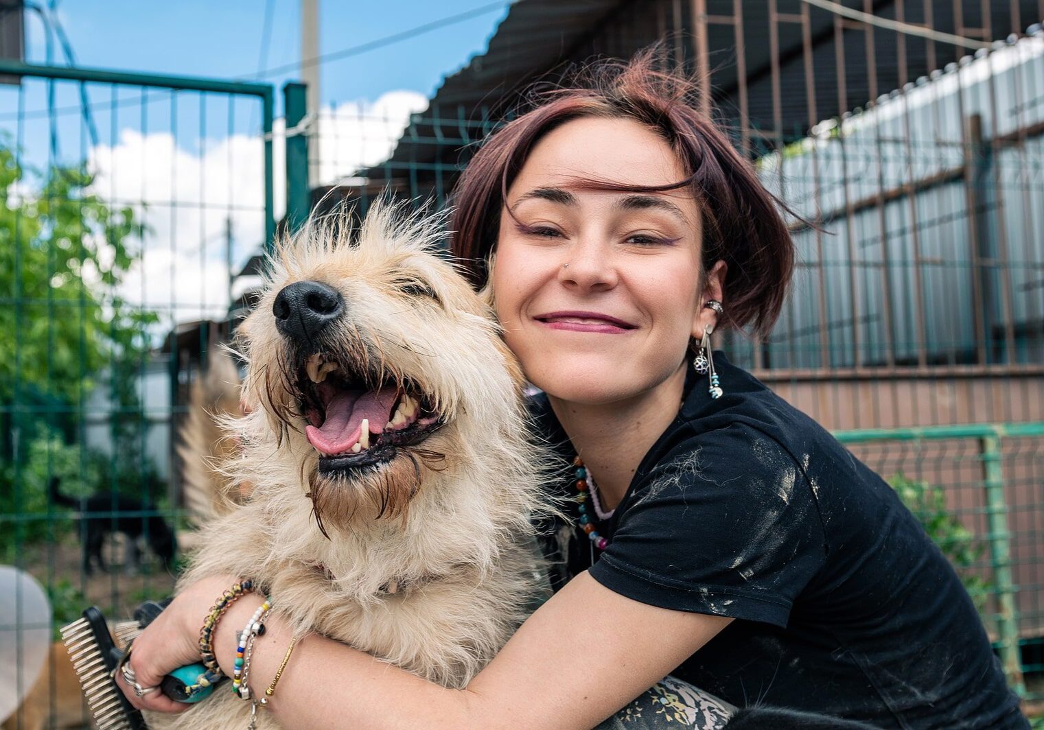 woman outside with her dog and hugging them