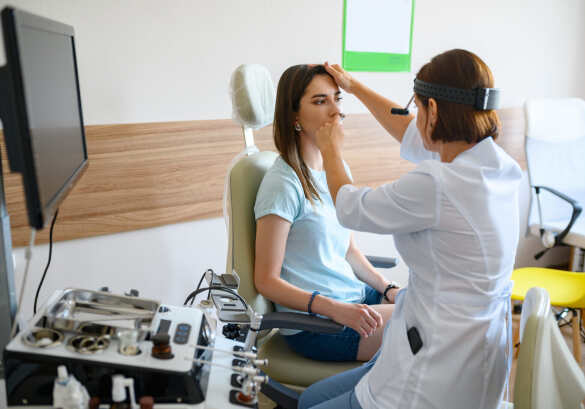 woman getting her nose looked at by the doctor