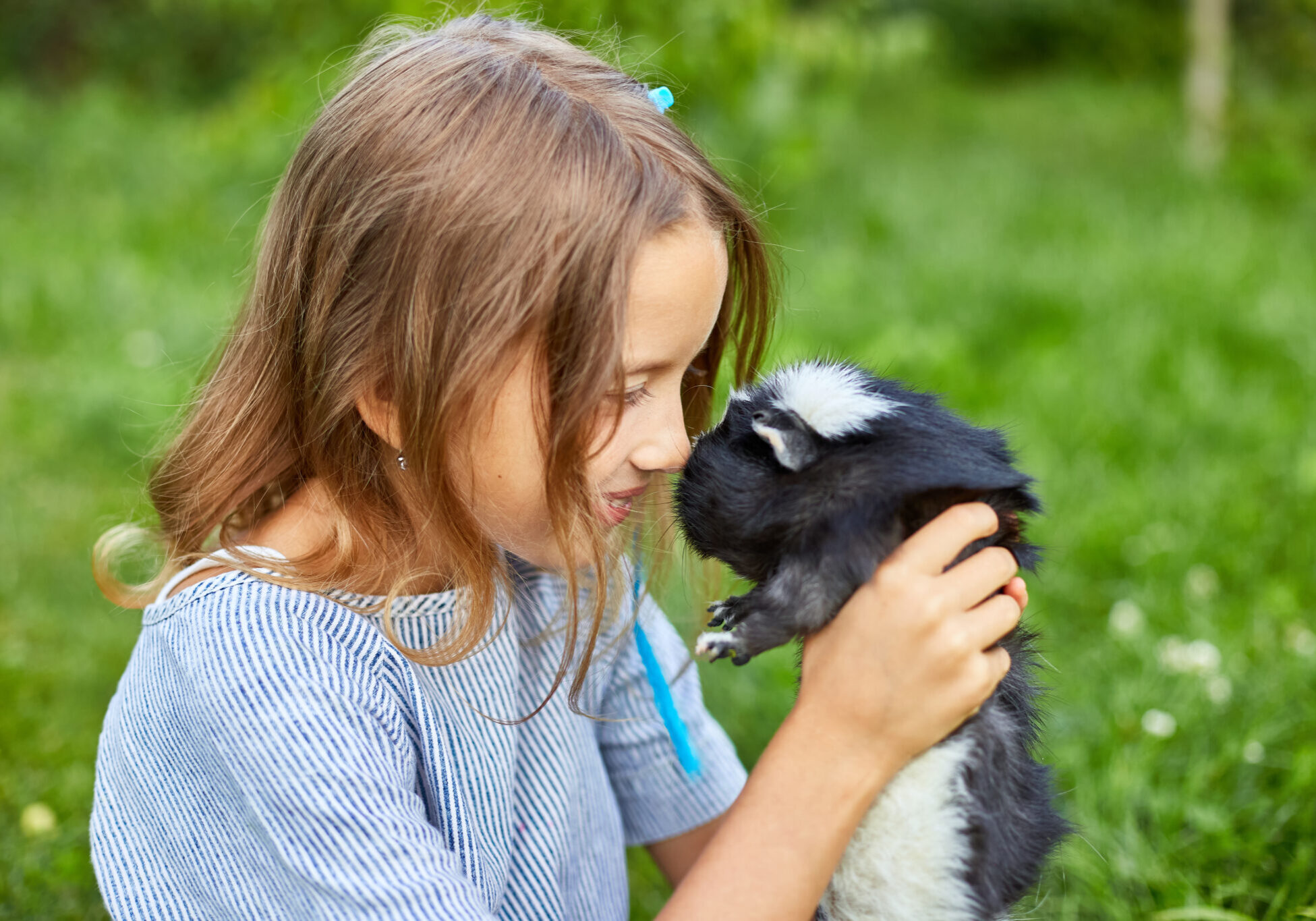 little girl holding a hamster and looking in his eyes