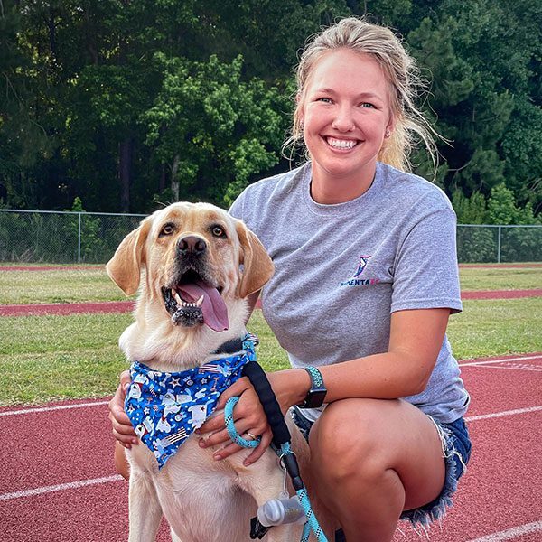 Nicole Humphrey hugging her dog on the running track