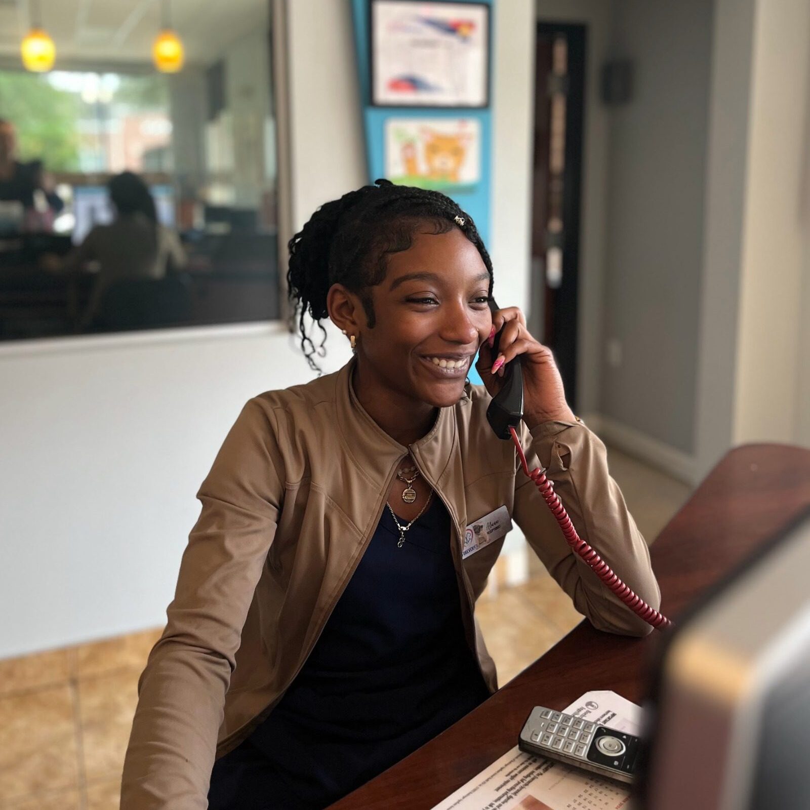 Smiling woman sitting at desk and answering phone